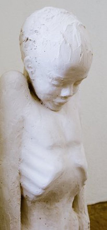 Statue eines Jungen mit gesenktem Kopf und unangezogenem Brustkorb